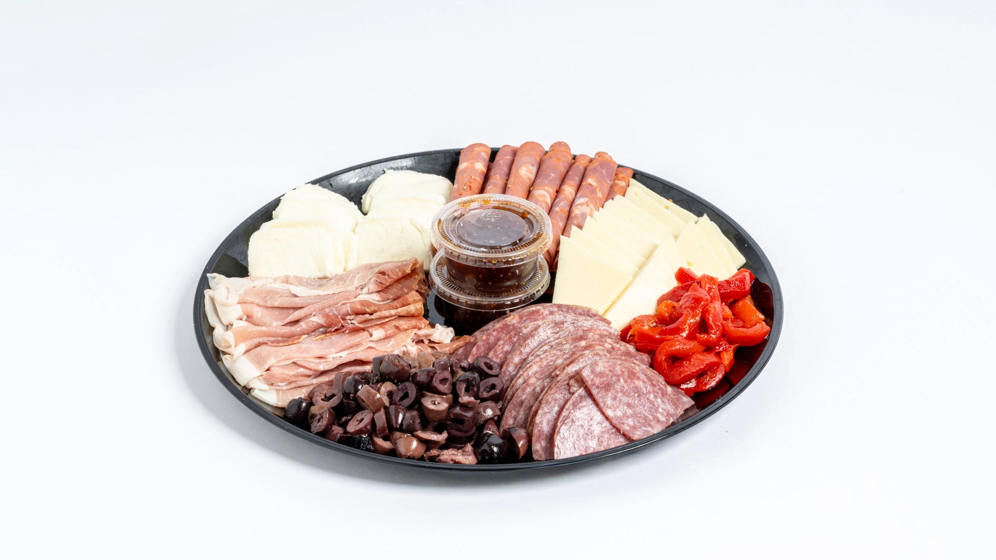 Assorted deli meats and cheeses on a black plate with a white background